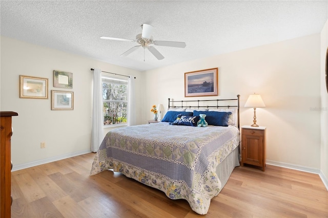 8097 SE 174th Belhaven Loop, The Villages, FL 32162 - bedroom featuring light wood-type flooring, a textured ceiling, baseboards, and a ceiling fan