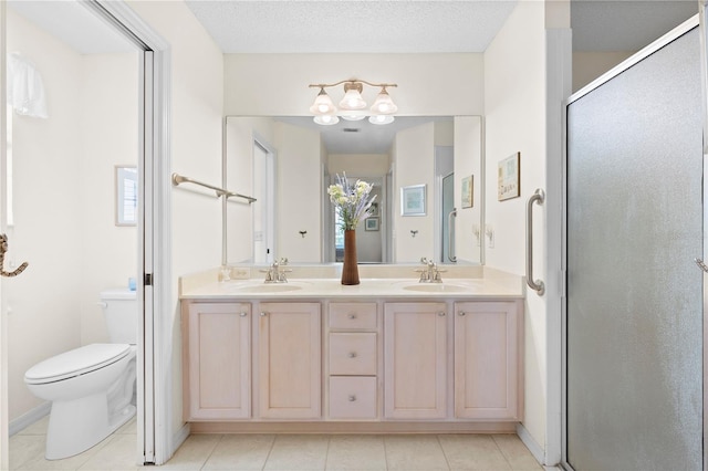 8097 SE 174th Belhaven Loop, The Villages, FL 32162 - bathroom with a shower stall, toilet, double vanity, tile patterned flooring, and healthy amount of natural light