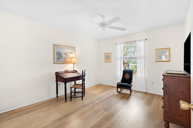 8097 SE 174th Belhaven Loop, The Villages, FL 32162 - sitting room with light wood-type flooring, ceiling fan, baseboards, and a textured ceiling
