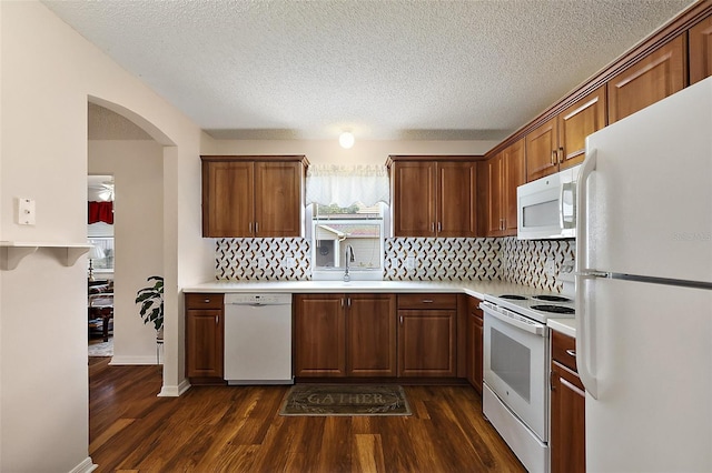 518 Alcazar Ct, The Villages, FL 32159 - kitchen with white appliances, dark wood-style flooring, light countertops, and a sink