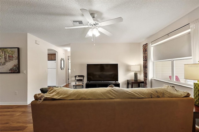 518 Alcazar Ct, The Villages, FL 32159 - living area featuring ceiling fan, visible vents, a textured ceiling, arched walkways, and wood finished floors