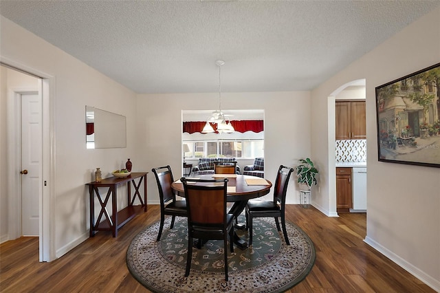 518 Alcazar Ct, The Villages, FL 32159 - dining area featuring dark wood-style flooring, baseboards, a textured ceiling, and arched walkways