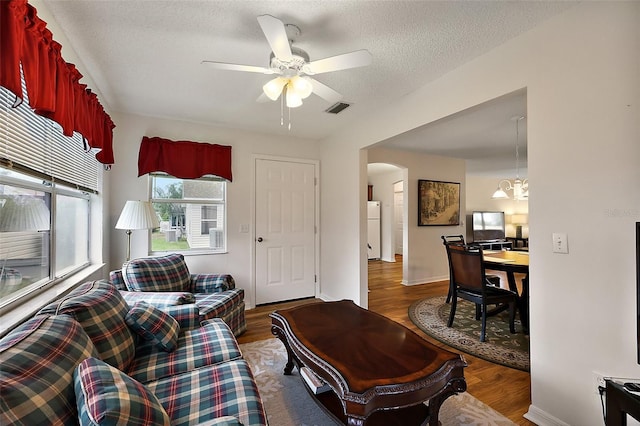 518 Alcazar Ct, The Villages, FL 32159 - living area with wood finished floors, arched walkways, ceiling fan with notable chandelier, baseboards, and visible vents