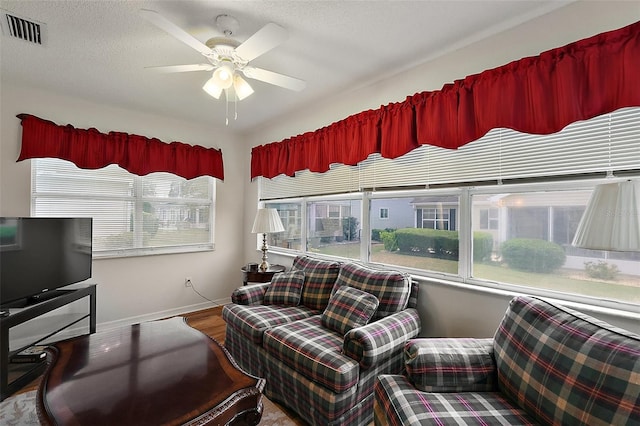 518 Alcazar Ct, The Villages, FL 32159 - living room featuring wood finished floors, visible vents, a ceiling fan, and baseboards