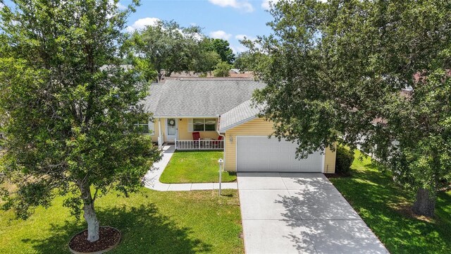 518 Alcazar Ct, The Villages, FL 32159 - obstructed view of property with a porch, a front yard, a garage, and concrete driveway