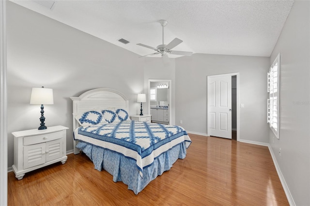 bedroom featuring baseboards, visible vents, lofted ceiling, and light wood finished floors