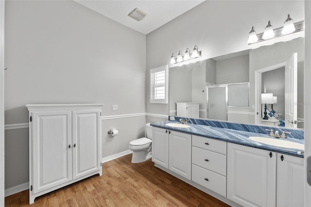 bathroom with double vanity, a sink, a shower stall, and visible vents
