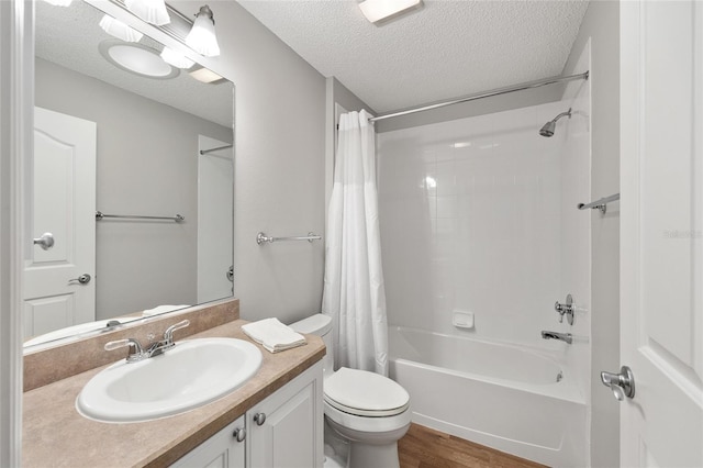 full bath featuring toilet, a textured ceiling, shower / bath combo, and vanity