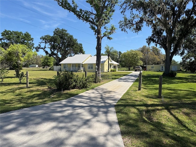 surrounding community featuring a lawn and concrete driveway