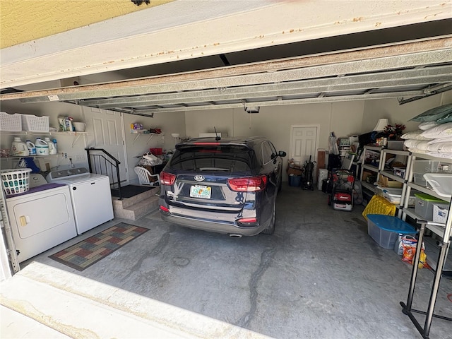 garage with a garage door opener and separate washer and dryer