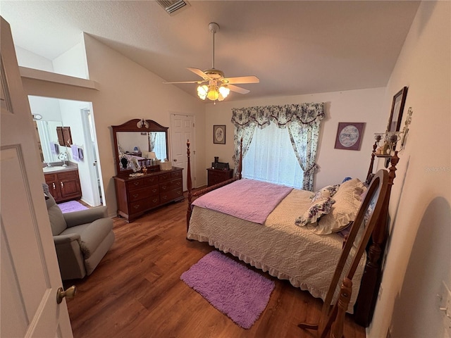 bedroom with connected bathroom, visible vents, vaulted ceiling, wood finished floors, and a ceiling fan