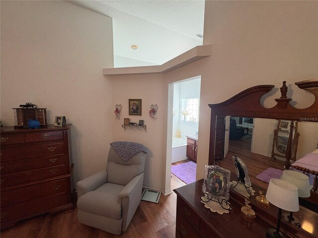 living area with lofted ceiling and wood finished floors