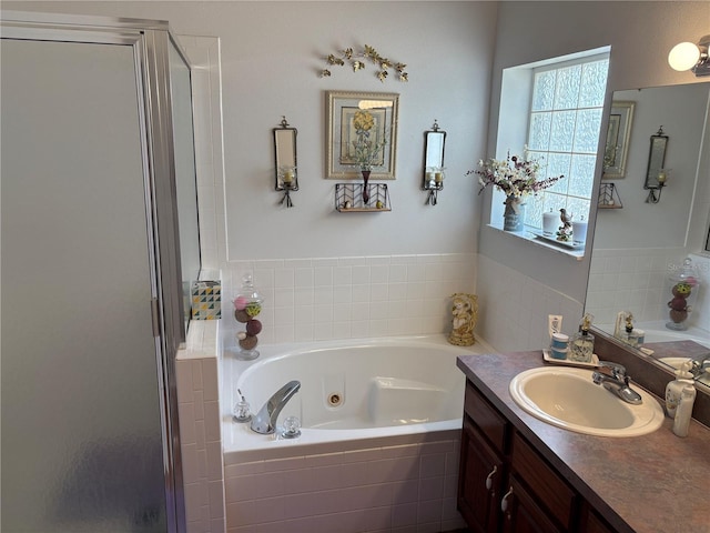 full bath with a tub with jets, vanity, and a shower stall