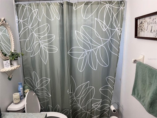 bathroom featuring toilet and a shower with shower curtain