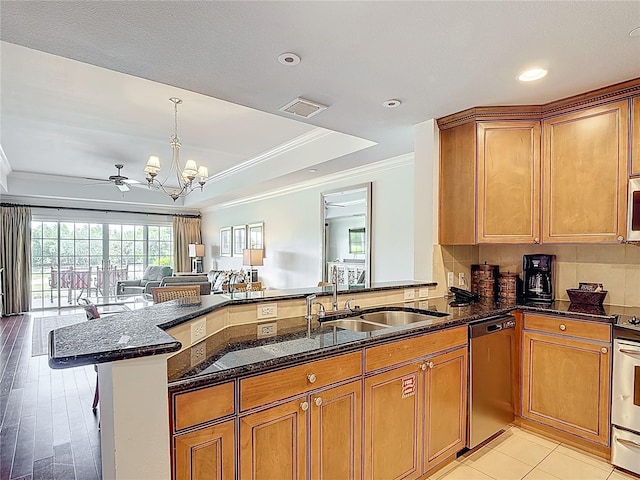 1356 Centre Court Ridge Dr Unit 103, Reunion, FL 34747 - kitchen featuring crown molding, brown cabinets, open floor plan, a raised ceiling, and appliances with stainless steel finishes
