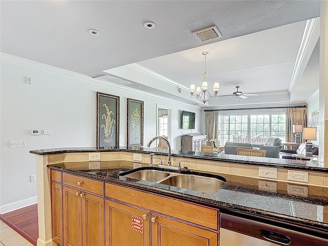 1356 Centre Court Ridge Dr Unit 103, Reunion, FL 34747 - kitchen featuring stainless steel dishwasher, a tray ceiling, a sink, brown cabinets, and ornamental molding