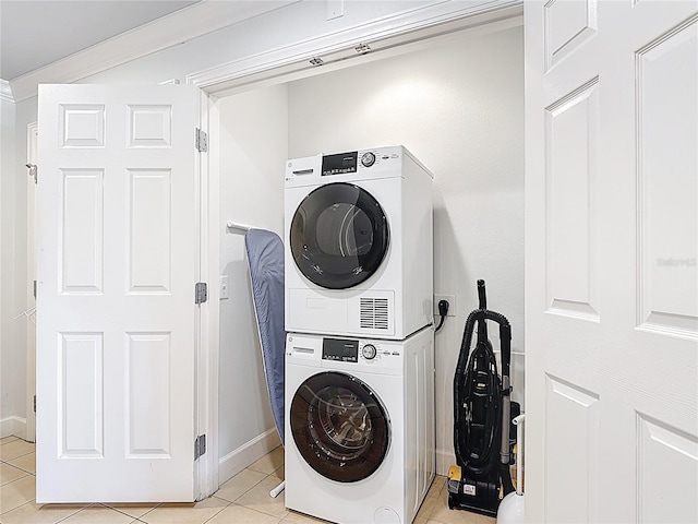 1356 Centre Court Ridge Dr Unit 103, Reunion, FL 34747 - clothes washing area with stacked washer and clothes dryer, baseboards, light tile patterned floors, and laundry area