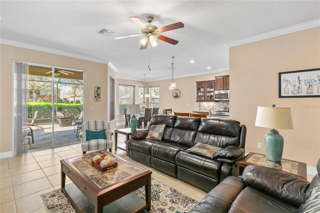living area with ceiling fan, crown molding, visible vents, and light tile patterned floors