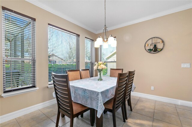 tiled dining room with baseboards, crown molding, and a chandelier