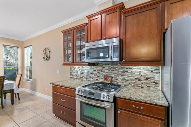kitchen featuring tasteful backsplash, appliances with stainless steel finishes, baseboards, and ornamental molding