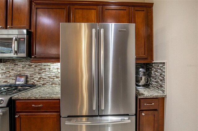 kitchen featuring backsplash, light stone countertops, and stainless steel appliances