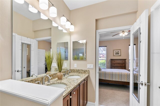 ensuite bathroom featuring ceiling fan, ensuite bath, a sink, and double vanity