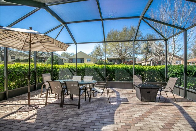 view of patio / terrace featuring outdoor dining area and glass enclosure