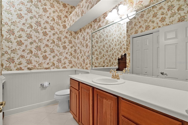 1721 Sunset Ridge Dr, The Villages, FL 32162 - bathroom featuring wallpapered walls, a wainscoted wall, vanity, toilet, and tile patterned flooring