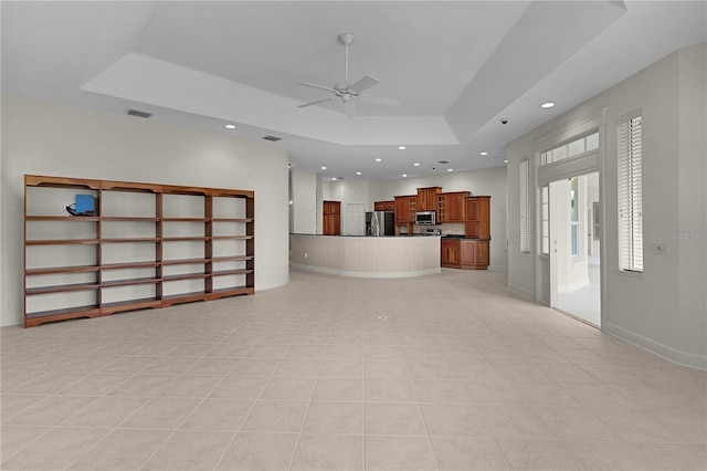 1721 Sunset Ridge Dr, The Villages, FL 32162 - unfurnished living room with a tray ceiling, a ceiling fan, recessed lighting, and light tile patterned flooring
