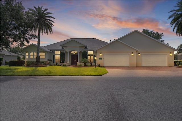 1721 Sunset Ridge Dr, The Villages, FL 32162 - view of front of home with driveway, an attached garage, a front lawn, and stucco siding