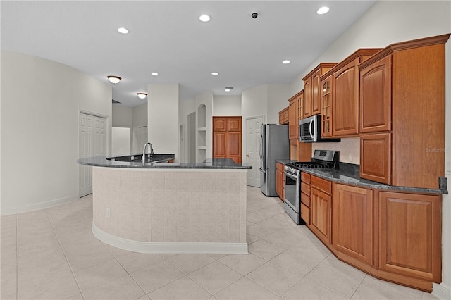 1721 Sunset Ridge Dr, The Villages, FL 32162 - kitchen with stainless steel appliances, brown cabinets, recessed lighting, a sink, and light tile patterned floors