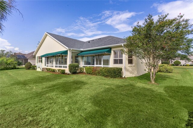 1721 Sunset Ridge Dr, The Villages, FL 32162 - back of property featuring a yard, stucco siding, and roof with shingles