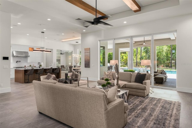 living room featuring a ceiling fan, beamed ceiling, recessed lighting, and baseboards