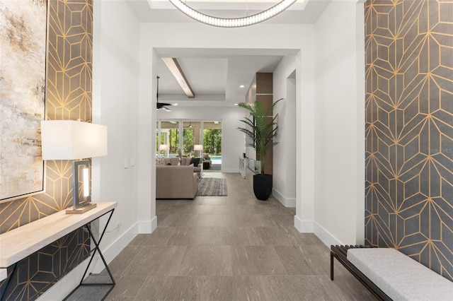 hall with beamed ceiling and baseboards
