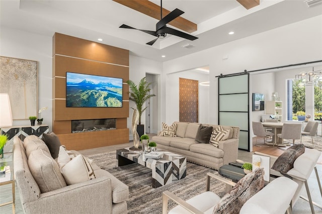 living area with recessed lighting, beam ceiling, a barn door, a ceiling fan, and visible vents