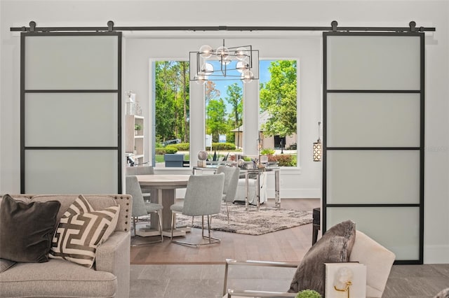 interior space with an inviting chandelier, baseboards, a barn door, and plenty of natural light