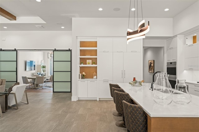 kitchen featuring white cabinetry, recessed lighting, stainless steel double oven, and modern cabinets