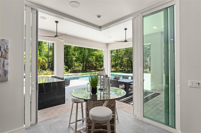 sunroom with outdoor dining area and ceiling fan