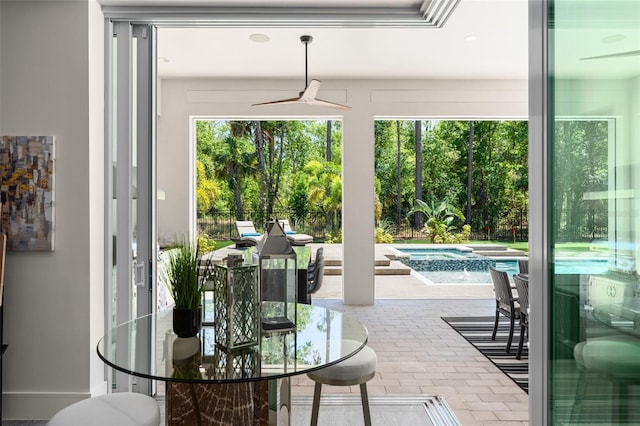 exterior space with a ceiling fan, brick floor, and plenty of natural light