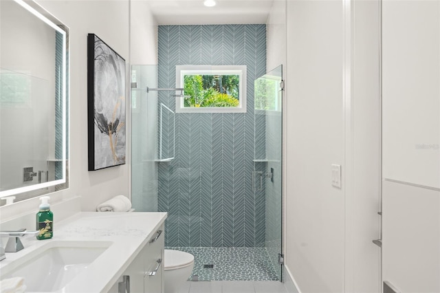 full bath featuring toilet, vanity, tile patterned flooring, and a stall shower