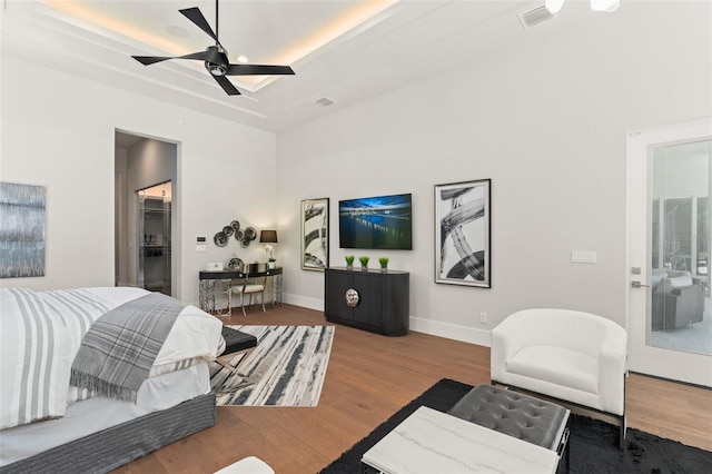 bedroom with visible vents, ceiling fan, wood finished floors, and baseboards