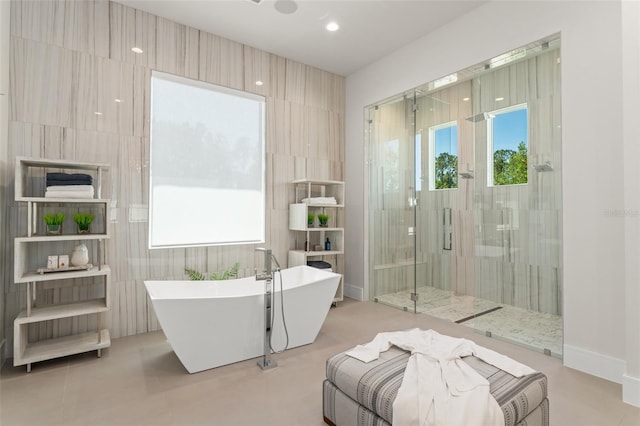 bathroom with a stall shower and a freestanding bath