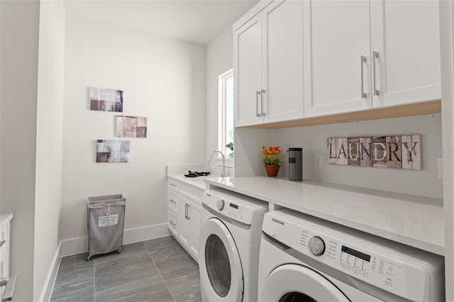 laundry room featuring washer and dryer, a sink, cabinet space, and baseboards
