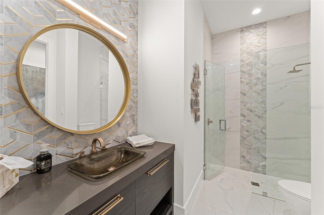 bathroom featuring vanity, toilet, a stall shower, backsplash, and baseboards