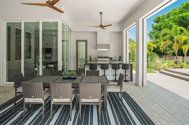 view of patio with area for grilling, a ceiling fan, a grill, and fence
