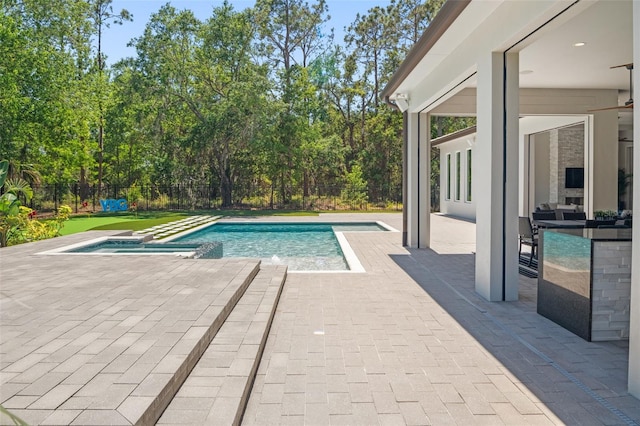 view of pool featuring a pool with connected hot tub, a patio, and a fenced backyard