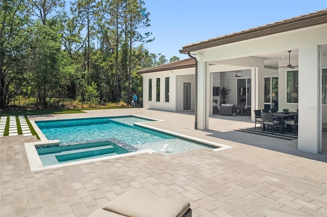 view of swimming pool featuring a ceiling fan, a pool with connected hot tub, and a patio area