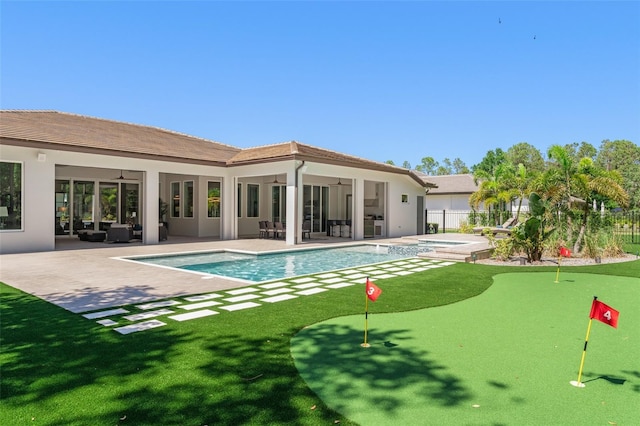 back of property with a ceiling fan, a fenced in pool, an in ground hot tub, and a patio area