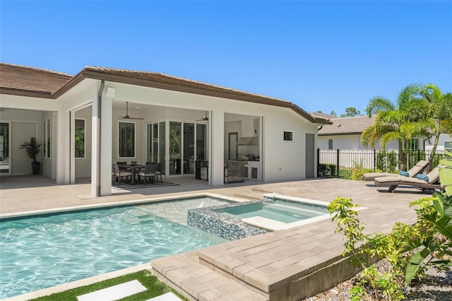 back of property with fence, a fenced in pool, a patio, an in ground hot tub, and a ceiling fan
