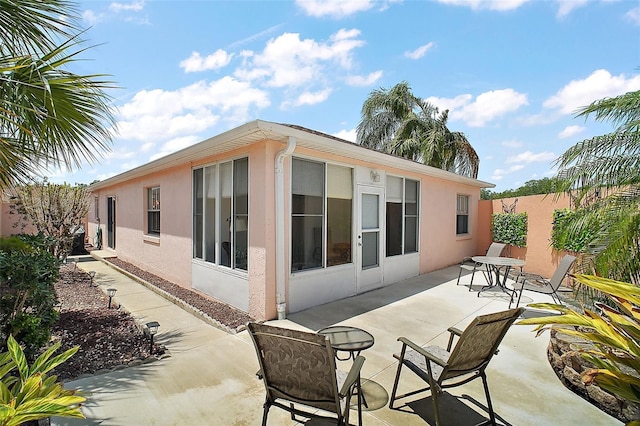 rear view of property with stucco siding and a patio